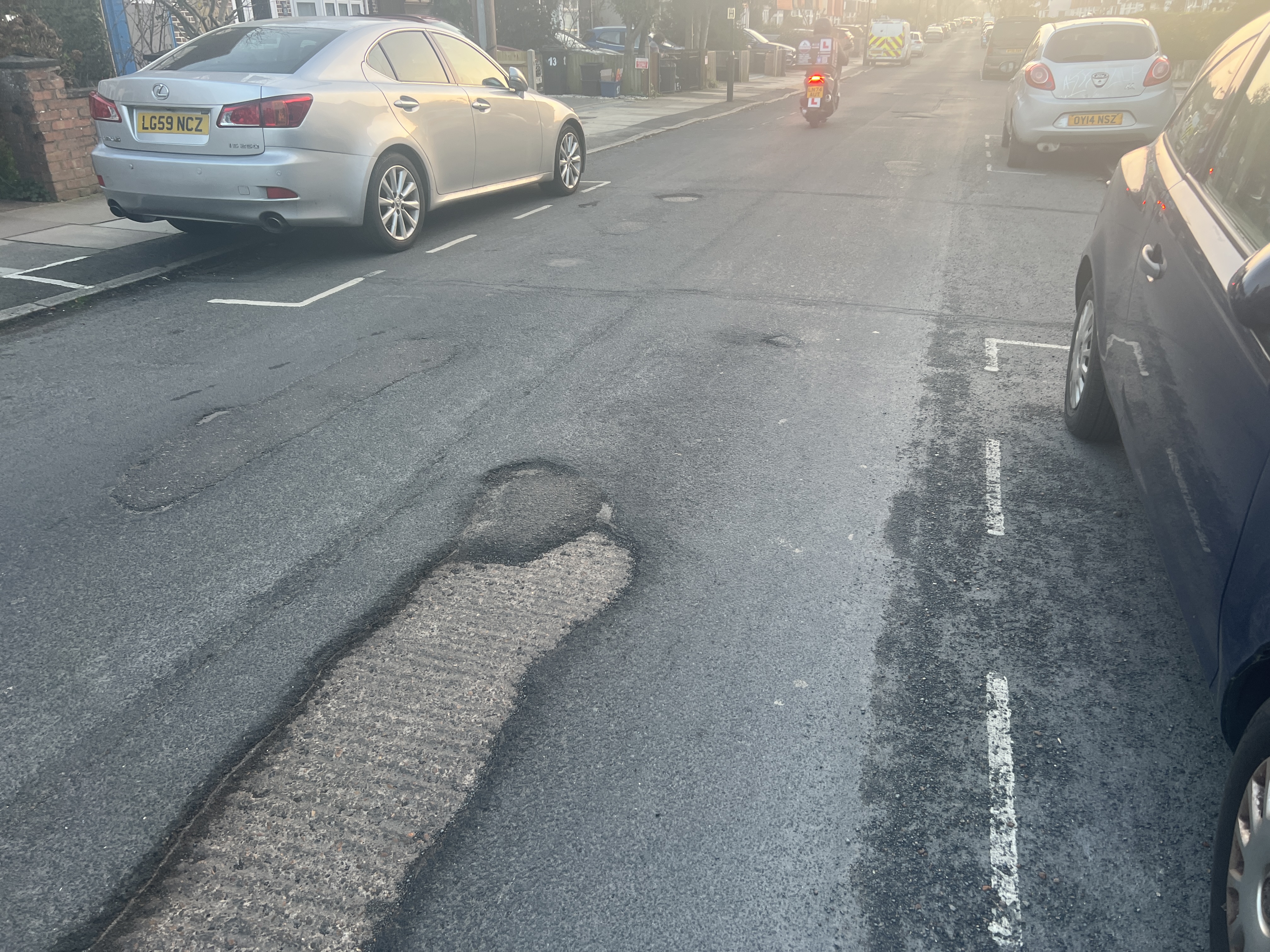 Example of surface wear and patch repair visible on a recently resurfaced residential road